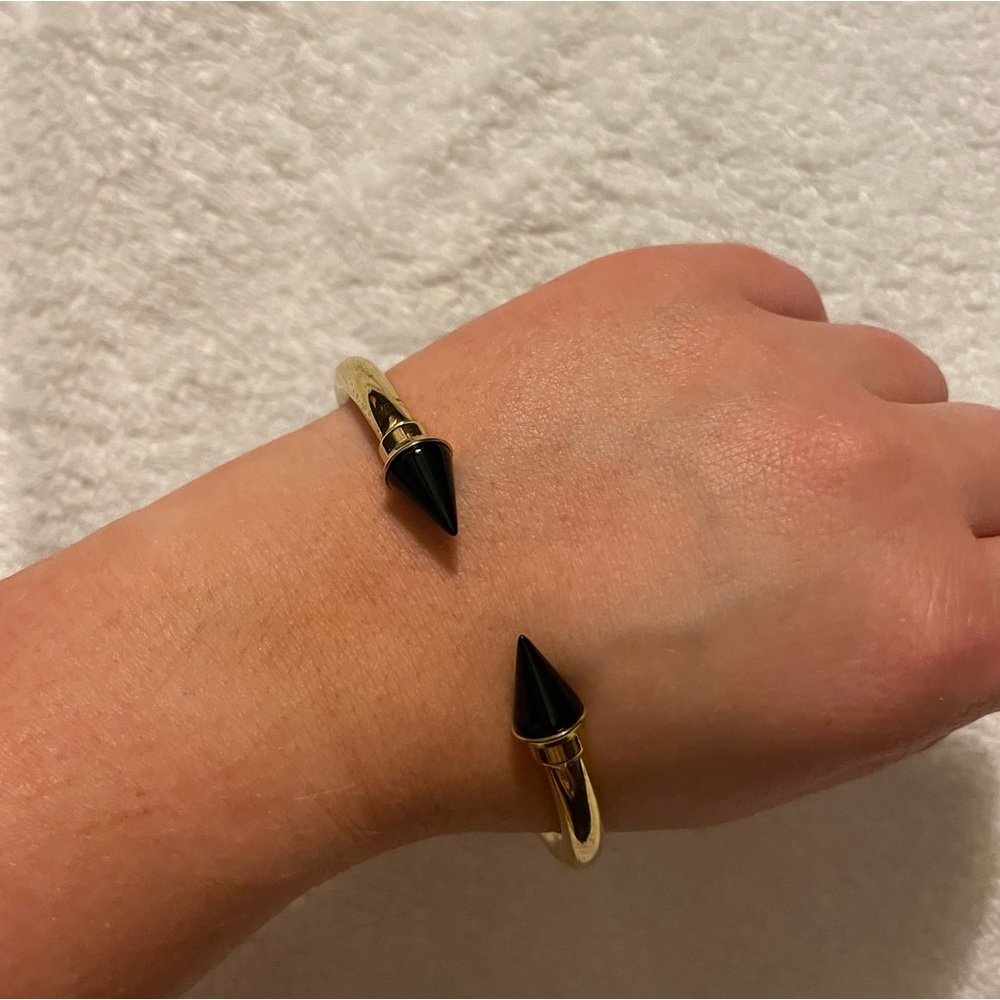 Barely used gold bracelet with black spikes